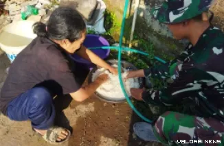 TMMD Reguler ke-129, personel TNI justru terlihat sibuk di dapur umum. Seragam loreng mereka berbaur dengan ibu-ibu desa yang sedang menyiapkan logistik, Minggu (19/7/2026).