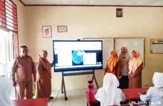 Irman A, Kepsek SMPN 2 Bayang (kiri) bersama para guru, terlihat gunakan Papan Interaktif Digital (PID), sebagai media pembelajaran, kepada para siswa. FOTO: Dok SMPN 2 Bayang