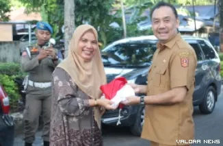 Wabup Agam, Muhammad Iqbal membagikan Bendera Merah Putih pada warga yang melintas di Simpang Lampu Merah RSUD Lubuk Basung. Selasa pagi. (anizur)