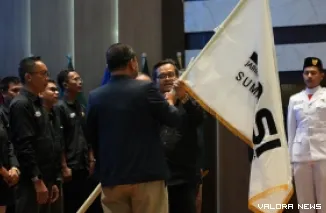 Ketua Bidang Organisasi PP JMSI, Dr Faisal Andri Mahrawa serahkan pataka pada Aguswanto usai pelantikan Pengda JMSI Sumbar periode 2026-2031 di aula kantor gubernur Sumbar, Sabtu pagi. (humas)