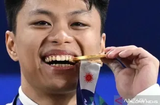 Rahmat Erwin Abdullah meraih medali emas setelah berada di posisi pertama sekaligus memecahkan rekor dunia kelas 75 kilogram untuk total angkatan 366 kilogram dan clean and jerk 206 kilogram. (Dok. ANTARA FOTO/Fauzan/nym.ANTARA FOTO/FAUZAN)