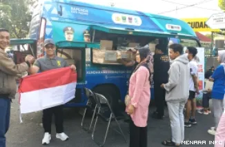 Kepala Bapenda Sumbar Al Amin Menyerahkan Bendera Merah Putih Kepada Salah Seorang Warga yang Membayar Pajak Hari Ini, Minggu (9/8/2026)