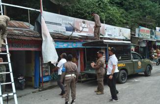 Satpol PP Tanah Datar Turunkan Reklame Tak Bayar Pajak