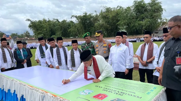 Bupati Benni Warlis saat penandatanganan deklarasi pesantren ramah anak usai acara Hari Santri Nasional tahun 2025 di Lapangan Bola Kaki Pitalo Nagari Pasie Ampek Angkek, Kabupaten Agam, Rabu (22/10/2025). (Foto Bacalahnews).