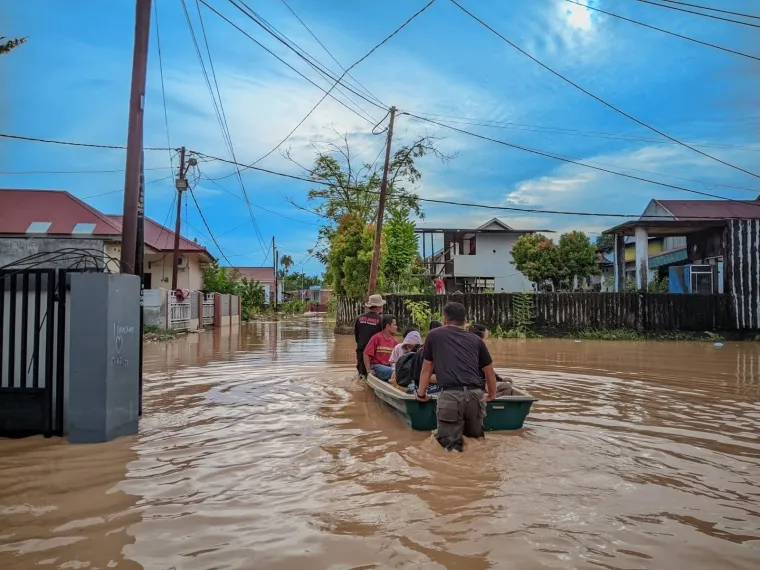 Para korban banjir di Kota Padang tengah dievakuasi menggunakan perahu kayu setelah rumah mereka teredam air. Dok