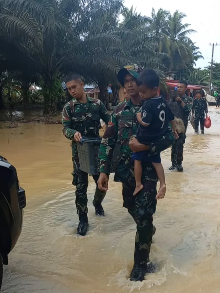 Para Prajurit Batalyon TP 897/Singgalang terlibat aktif dalam mengevakuasi warga yang terjebak banjir di Nagari Tiku V Jorong, Kecamatan Tanjung Mutiara, Kabupaten Agam, Jumat (28/11/2025). Foto Anizur