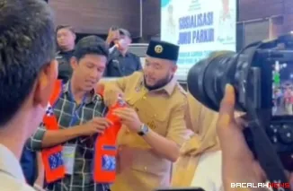 Wako Fadly Amran saat memasangkan rompi kepada seorang juru parkir pada kegiatan Sosialisasi Peningkatan Kualitas Juru Parkir di Ocean Beach Hotel, Selasa (18/11/25). (Foto Kominfo).