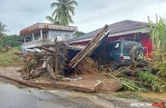 Terlihat sebuah rumah warga dan satu unit kendaraan rusak akibat material kayu dan lumpur dibawa arus banjir bandang. Foto Anizur
