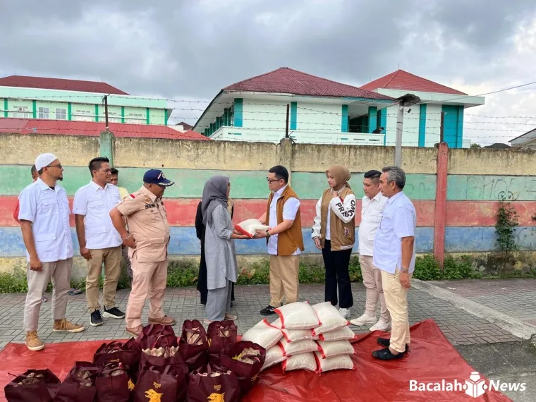 Sekretaris DPC Partai Gerinda Kota Bukittinggi, Reki Afriano saat menyerahkan bantuan bagi korban terdampak longsor di bibir Ngarai Sianok, Jumat (5/12/2025).