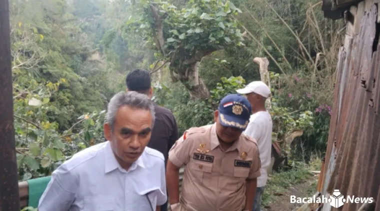 Terlihat anggota Fraksi Gerinda DPRD Kota Bukittinggi, Sabirin Rachmat berada di bibir Ngarai belakang rumah salah seorang warga dalam kegiatan penyaluran bantuan sembako. Foto Armanca.