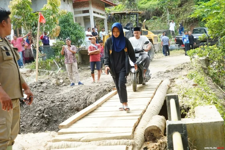Pembuatan jembatan sementara untuk menghubungkan dua daerah yang terputus akibat banjir bandang.