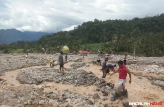 Terlihat sejumlah warga di daerah Sungai Batang Kabupaten Agam goro bersihkan meterial batu dan kayu pascabanjir susulan melada, Selasa (16/12/2025) malam. Foto Anizur.