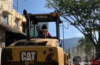 Terlihat alat berat membersihkan material lumpur di kawasan jalan kota Padang. Foto Dok