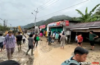 Terlihat warga bersama-sama tengah melakukan pembersihan lumpur di badan jalan dan juga dibantu alat berat sehingga jalan utama Bukittinggi - Lubuk Basung kembali bisa dilewati. Foto Anizur.