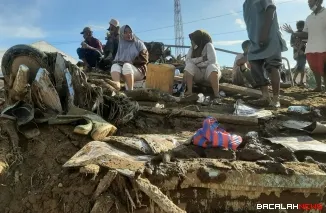 Sejumlah warga duduk di tumpukan material kayu pasca bencana banjir melanda tempat tinggal mereka di Kabupaten Agam. Foto Anizur.