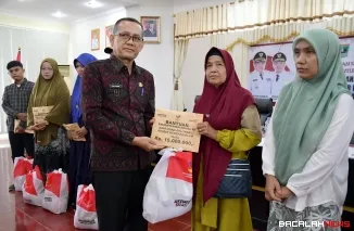 Kepala Dinas Sosial Agam Villa Erdi saat menyalurkan santunan uang duka dari Kementerian Sosial RI kepada ahli waris korban bencana di aula utama Kantor Bupati Agam, Kamis (15/1/2026). Foto Anizur, S.H