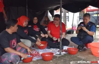 Ketua DPP PDI Perjuangan Bidang Kesehatan, dr Ribka Tjiptaning didampingi Alex Indra Lukman (Ketua PDI Perjuangan Sumbar) dan relawan, ikut mengupas bawang di dapur umum di rumah aspirasi Alex di kawasan Ulak Karang, Padang, Sabtu siang. (humas)