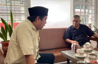 Wakil Ketua DPRD Kota Bukittinggi, H Zulhamdi Nova Candra IB Amd Pangulu Alam menggunakan peci hitam saat berdialog dengan Ketua PMI Bukittinggi H Chairunnas. Foto istimewa
