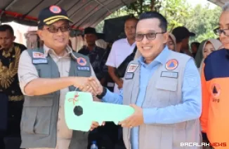 Sekretaris Utama Dr. Rustian, S.Si., Apt. M. Kes (rompi hijau dan topi hitam) saat menghadiri peresmian hunian sementara di Kecamatan Batipuh Selatan, Kabupaten Tanah Datar, Sumatra Barat pada Kamis (5/2).