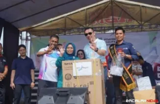 Kepala Cabang  Bank Nagari Dharmasraya Rusdi menyerahkan doorprize kepada peserta pada kegiatan Car Free Day Dharmasraya.
